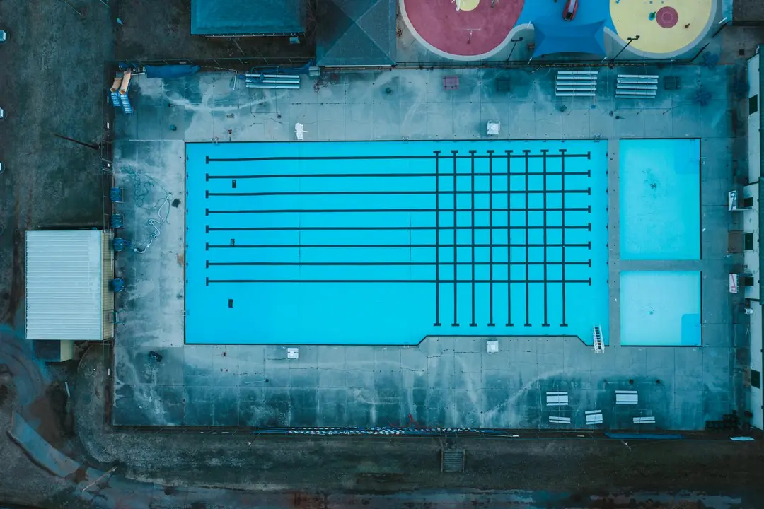 Aerial view of a community swimming pool with blue water and lane markings