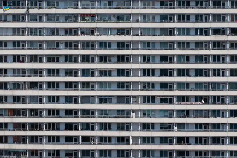 Facade of a multi-story apartment building with uniform rows of balconies.