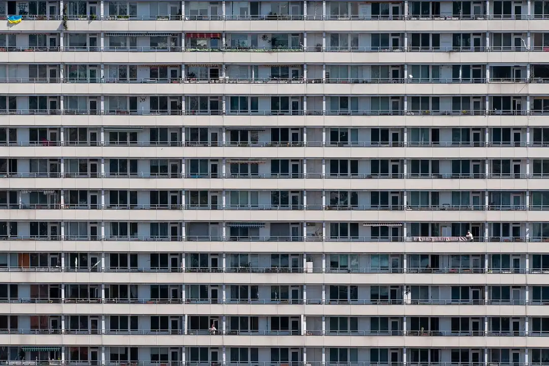 Facade of a multi-story apartment building with uniform rows of balconies.