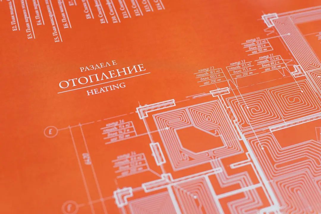Close-up of an architectural blueprint with an orange overlay and white lines, focusing on the heating section
