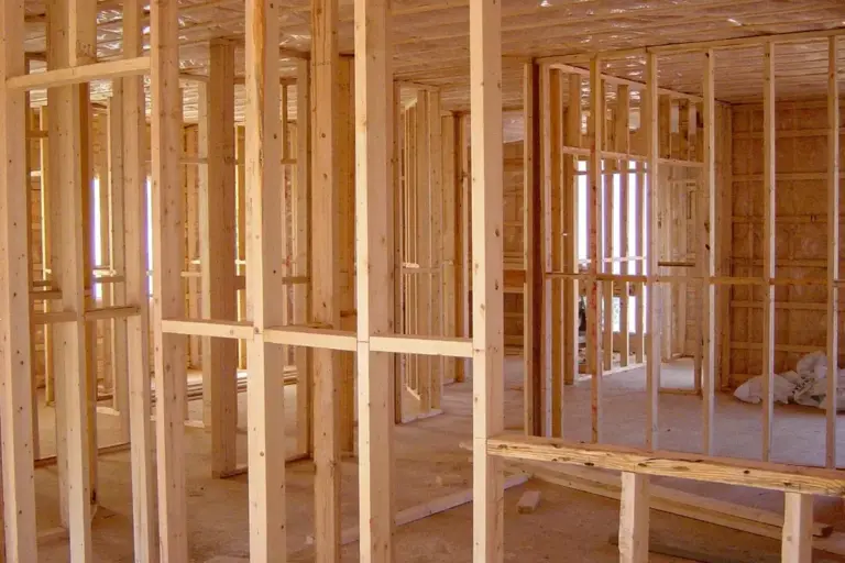 Interior of a house under construction with wooden framing and exposed studs