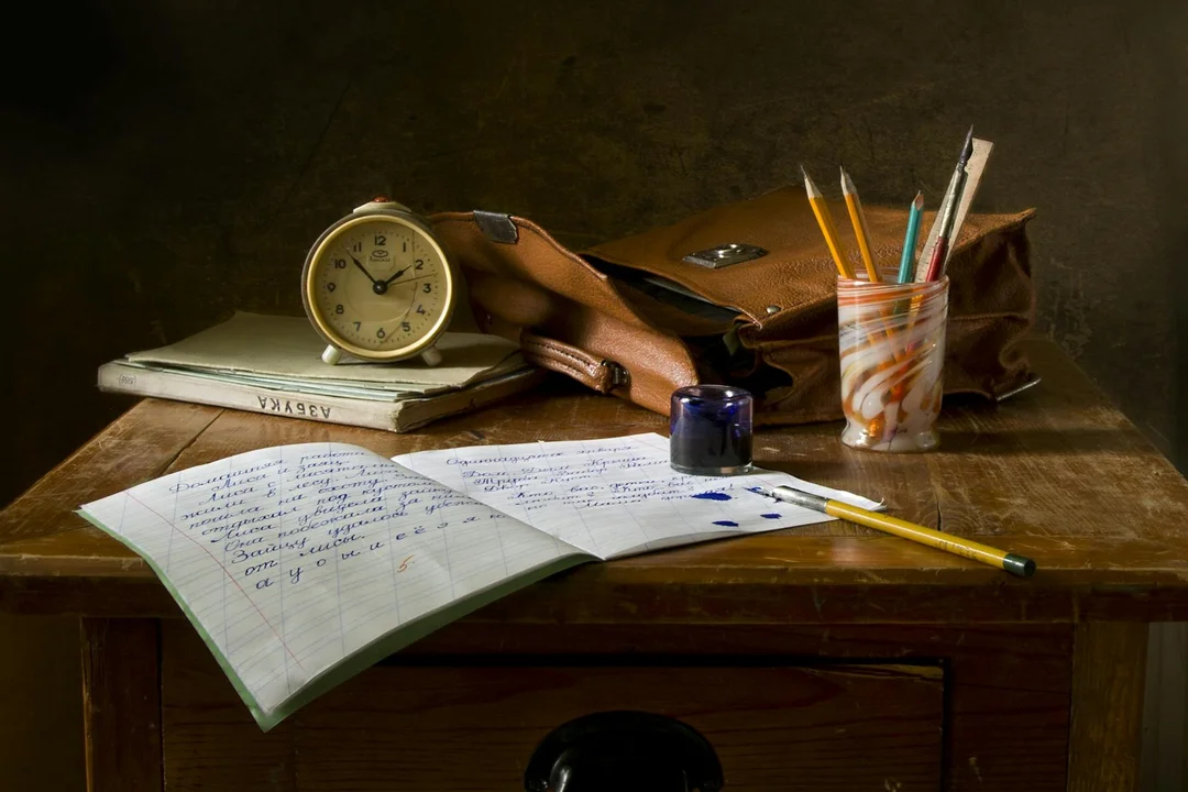 Old wooden desk with papers, a notebook, clock, and writing tools representing administrative work on HOA documents