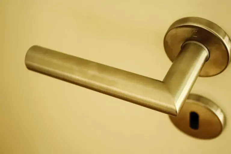 Close-up of a brass door handle on a beige door