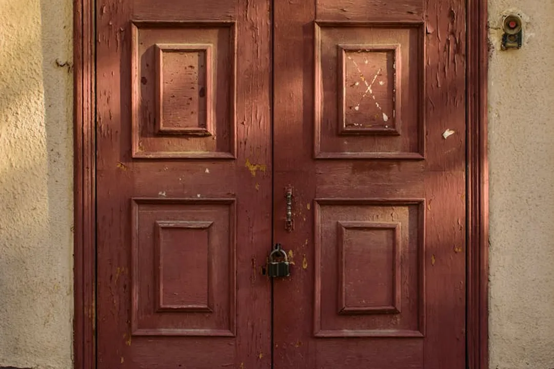 Wooden double front door with a padlock, representing restricted access and privacy considerations in HOA agreements.