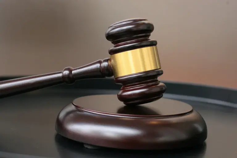 Close-up of a wooden gavel with a brass band resting on a sound block, symbolizing legal decisions about HOA rules and CC&Rs.