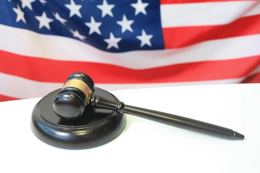 A gavel on a desk with an American flag in the background, symbolizing enforcement of HOA fines under governing documents.