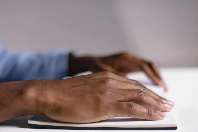 Close-up of hands typing on a tablet, symbolizing reviewing HOA maintenance guidelines