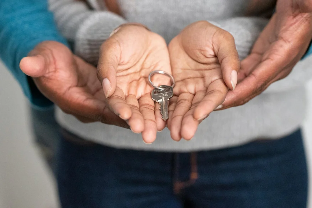 Close-up of hands holding a key, symbolizing rental access and HOA compliance