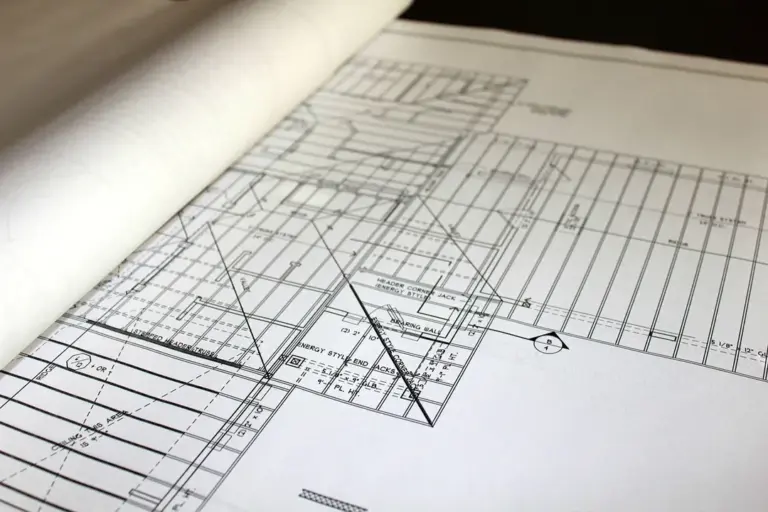 Close-up of architectural blueprints and drafting tools to symbolize strategic planning for homeowners associations