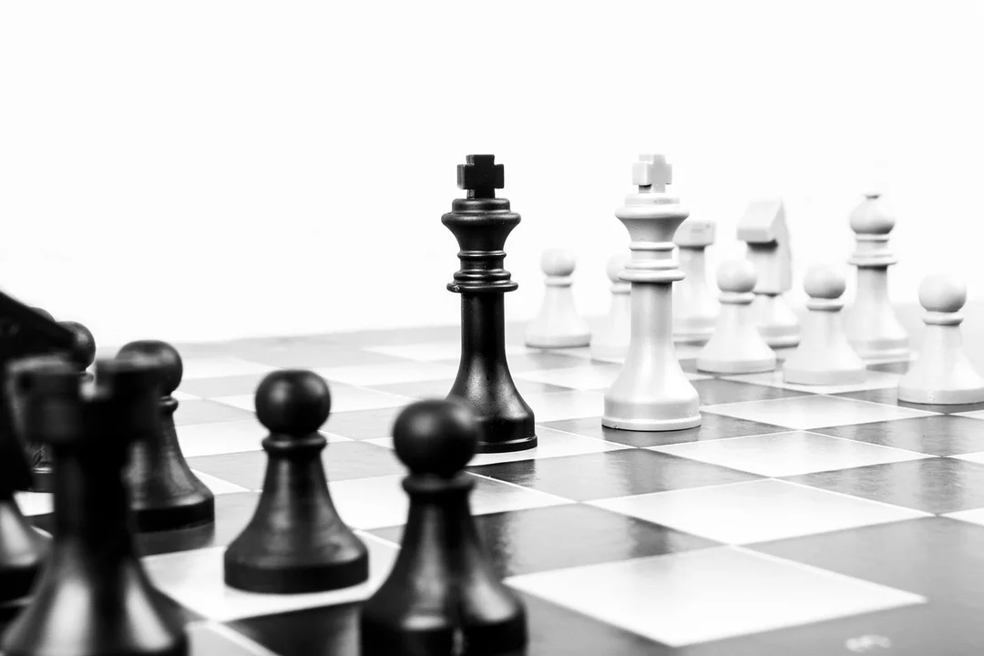 Black and white chessboard with pieces in focus, symbolizing governance and strategic decisions around HOA board term limits.