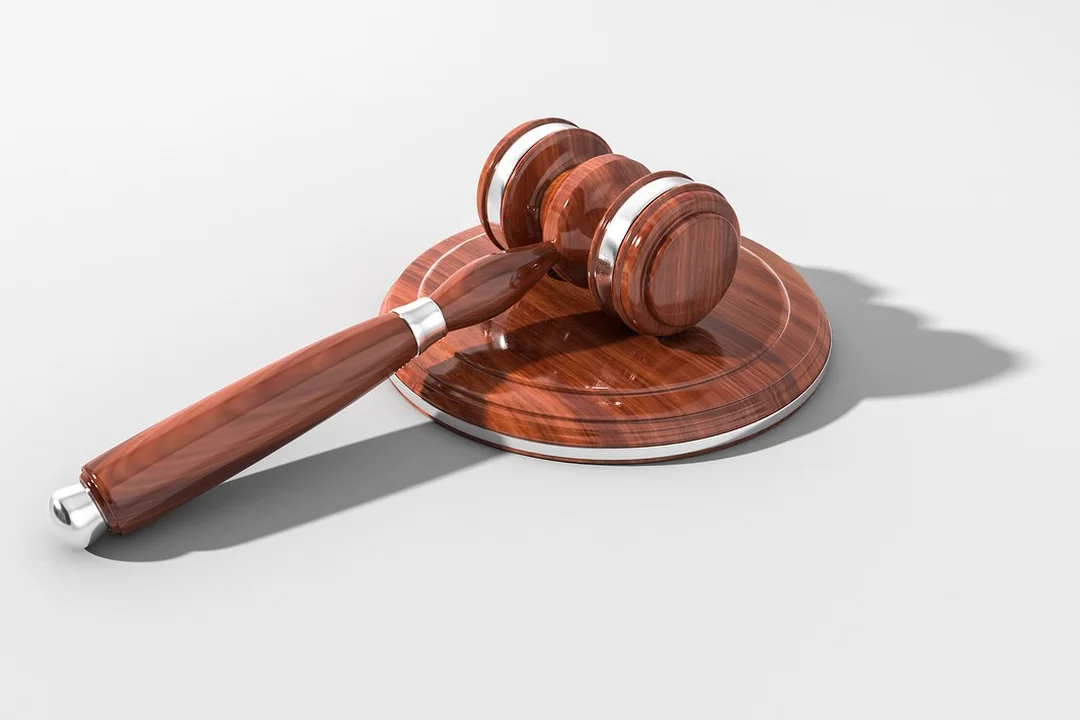 Wooden judge's gavel resting on a round wooden sound block