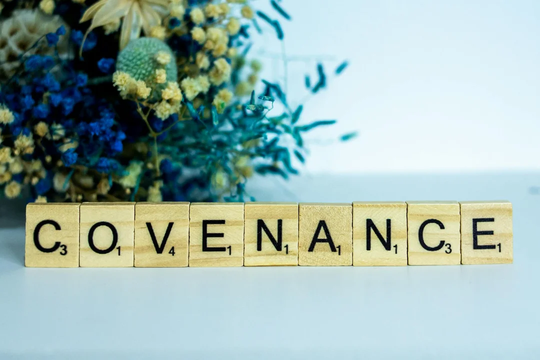 Scrabble-style tiles spell 'COVENANCE' with a bouquet of flowers in the background.