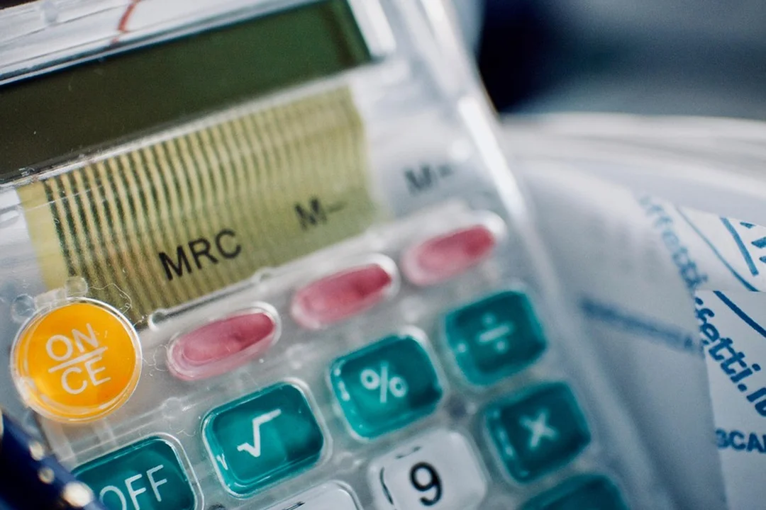 Close-up of a calculator with financial paperwork, symbolizing mortgage escrow and HOA fee changes.
