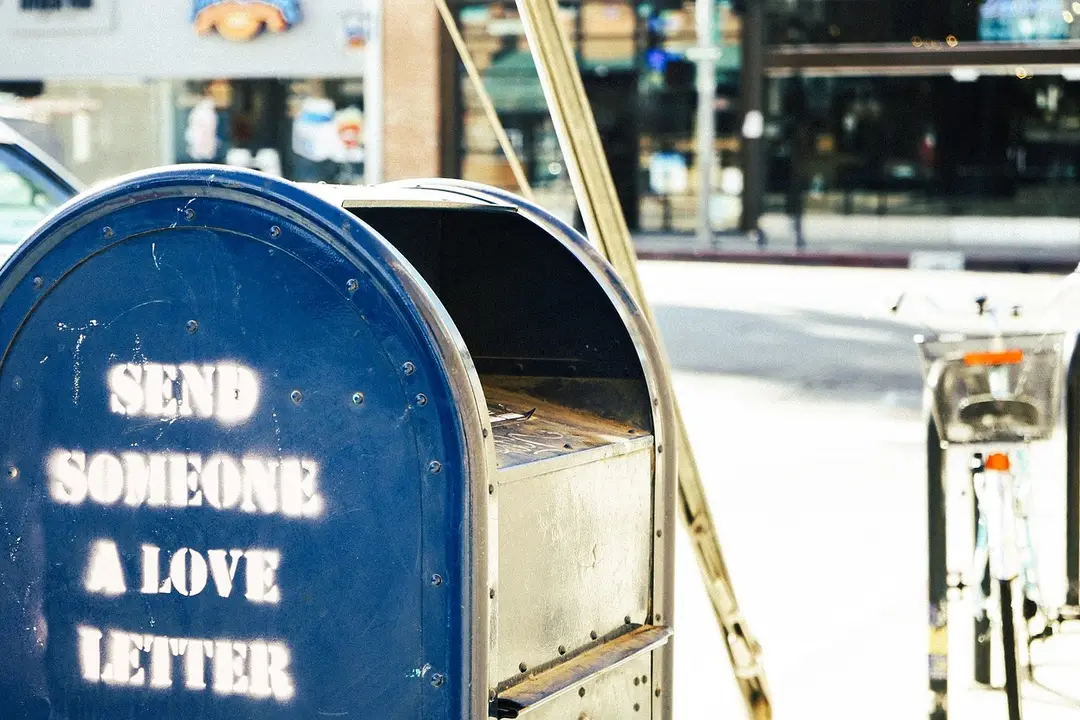 Blue mailbox with a stencil reading 'SEND SOMEONE A LOVE LETTER'.