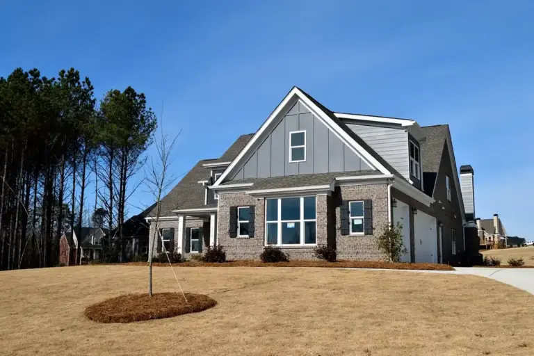 Suburban single-family home with a manicured yard and clear blue sky, representing communities with homeowners associations.