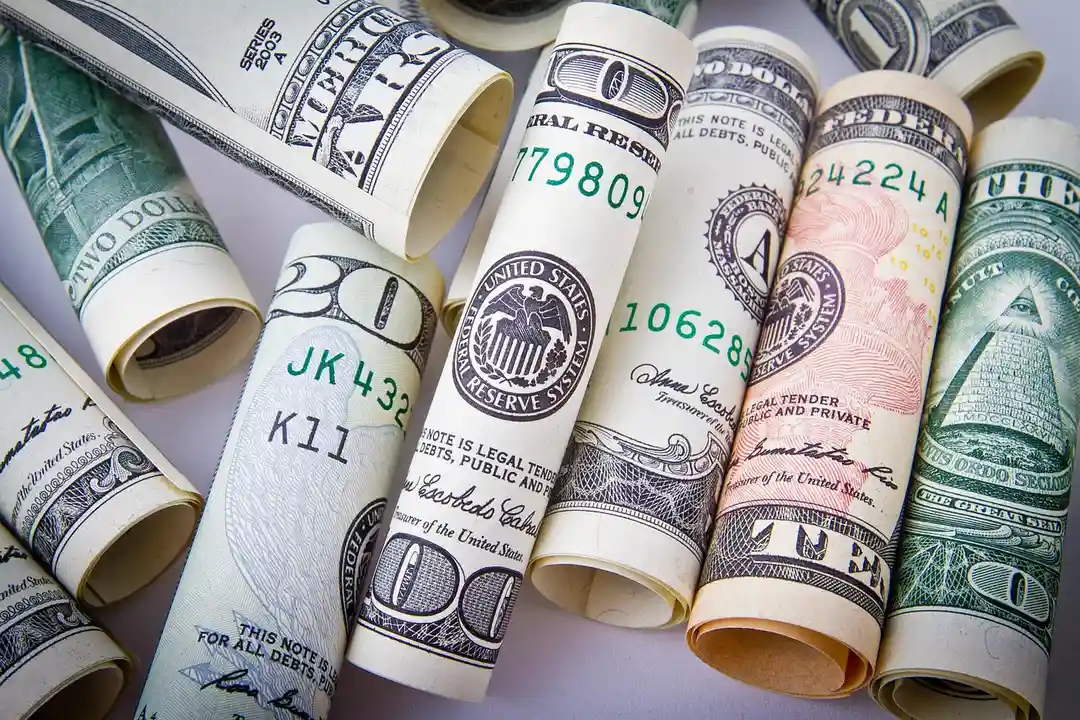 Rolled U.S. dollar bills representing financial oversight for HOA bank accounts
