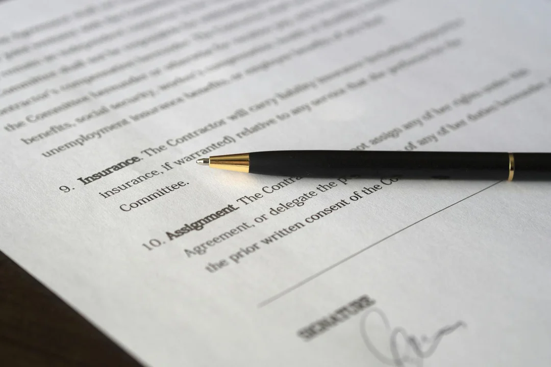 Close-up of a printed insurance document with a black pen resting on it, symbolizing gathering documents for an HOA master insurance claim.