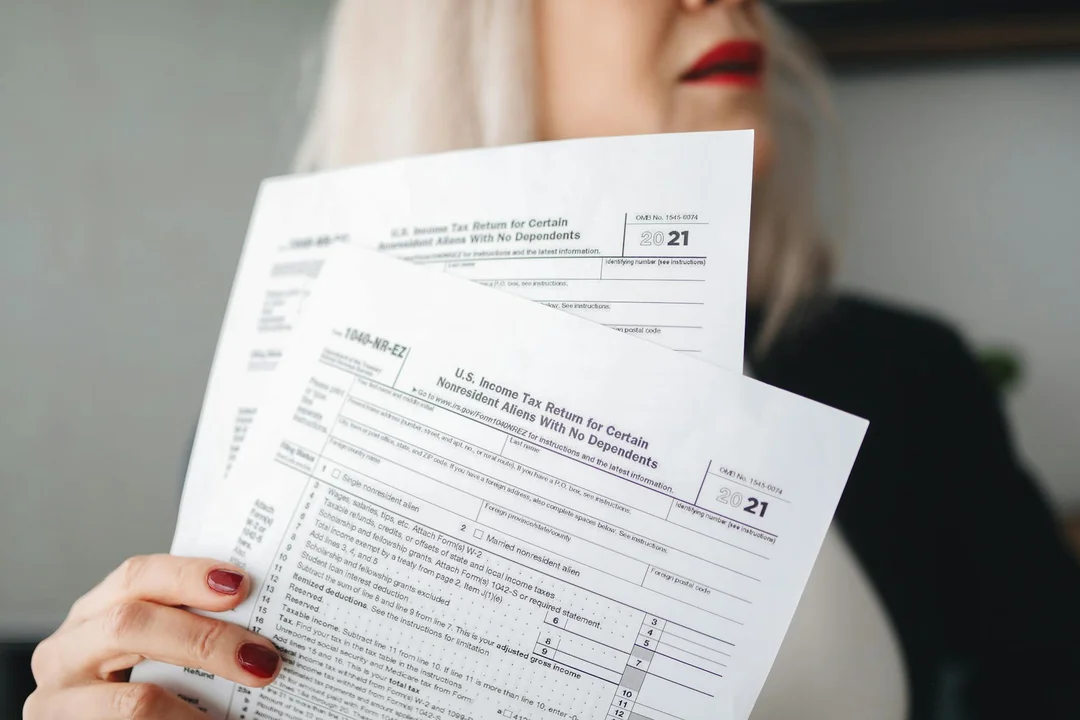 Person holding official-looking forms and documents related to HOA records
