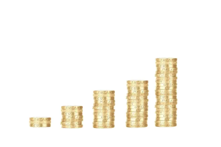 Stacks of gold coins increasing in height, illustrating HOA tax considerations and Form 1120-H exemptions