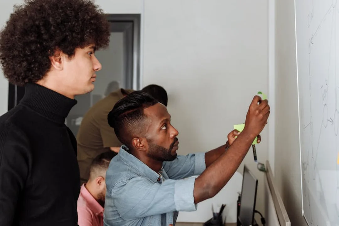 Diverse HOA board members collaborate at a whiteboard during a planning session