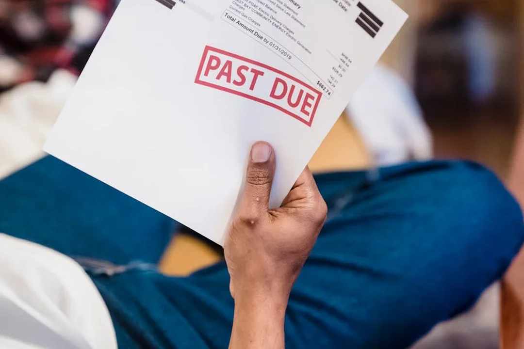 A person holding a past-due notice, signaling potential financial issues in an HOA budget
