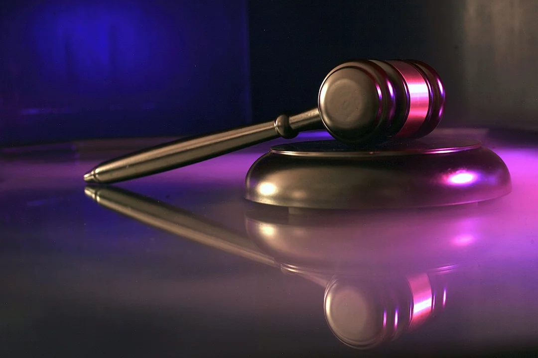 Gavel resting on a reflective surface with purple lighting, representing consistent and fair enforcement of HOA bylaws.