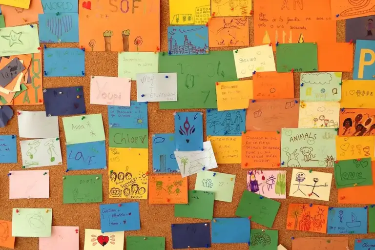 Colorful sticky notes on a corkboard, representing brainstorming and planning for HOA communication.