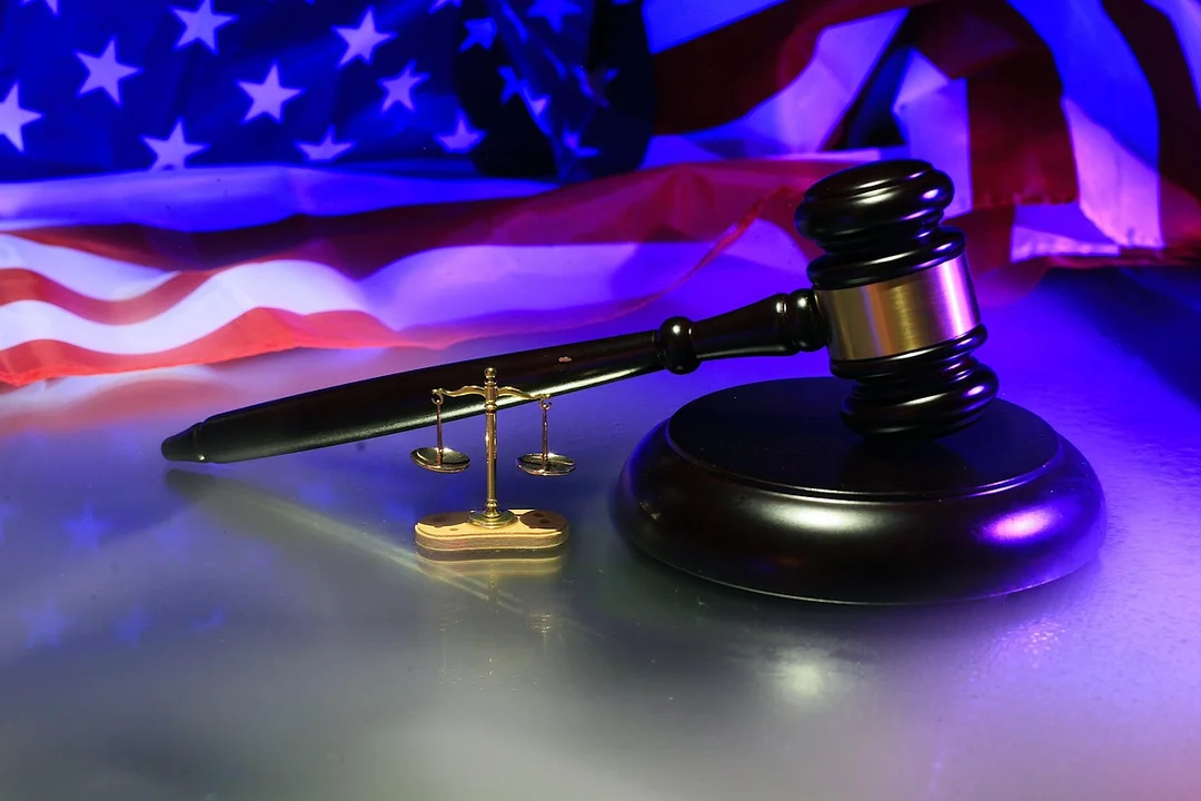 Gavel and scales of justice with an American flag in the background, symbolizing dispute resolution and enforcement in homeowners associations.