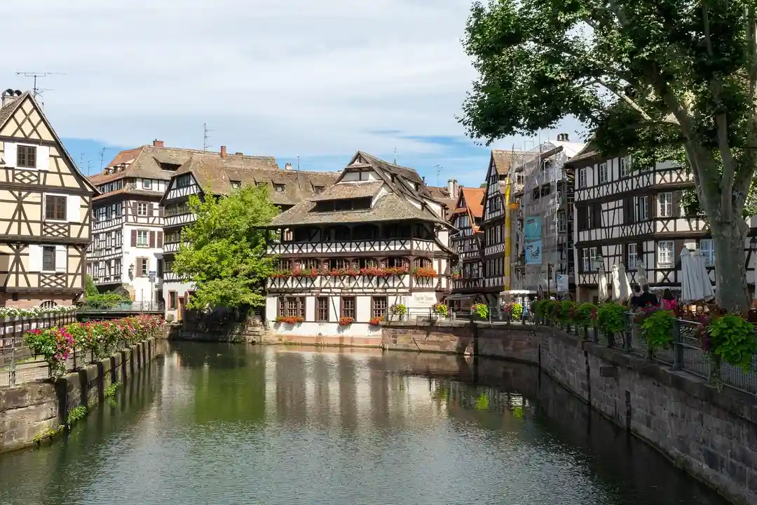 Timber-framed houses along a canal in a picturesque European town.