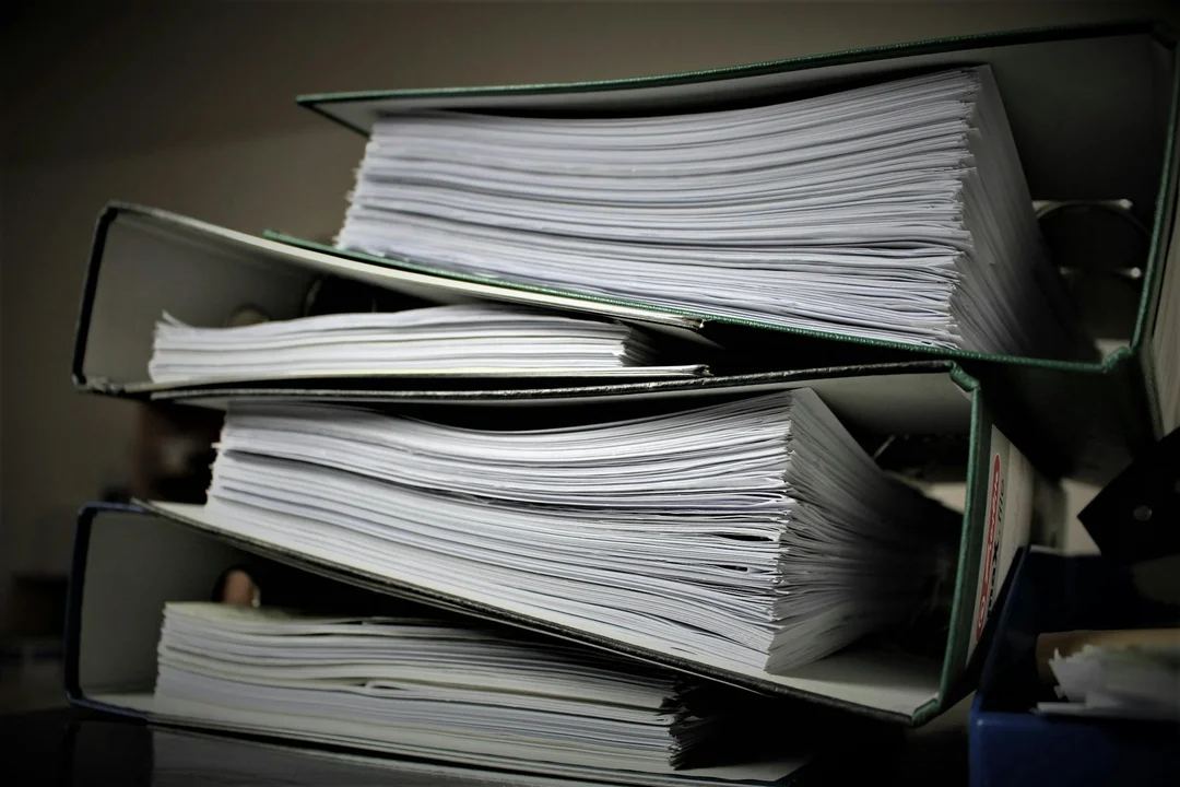 Stacks of documents in binders on a desk, symbolizing the winding up of a homeowners association's affairs.