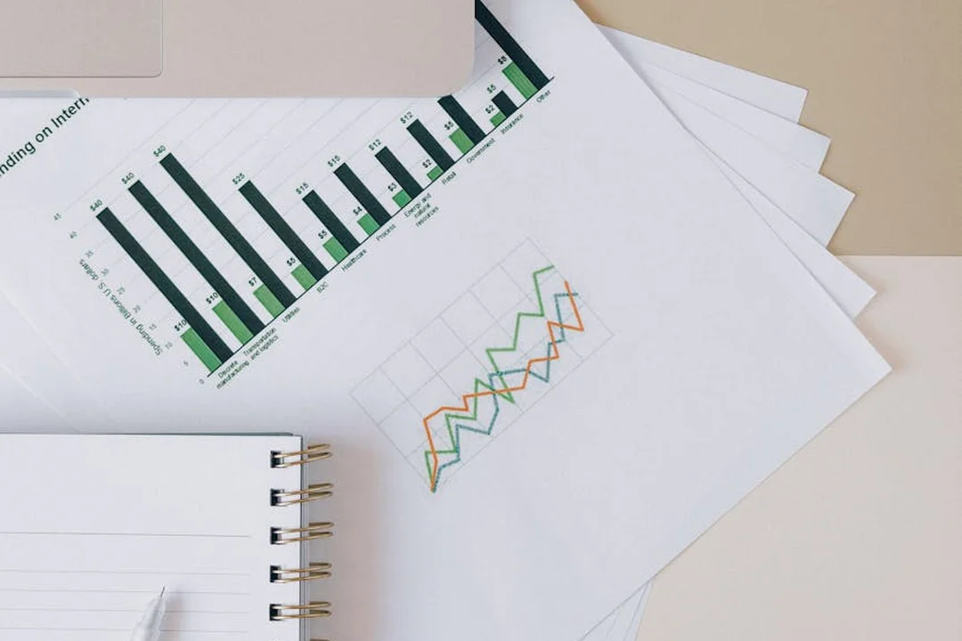 Close-up of financial charts, graphs, and a notebook on a desk, illustrating data review and the process of requesting HOA financial statements