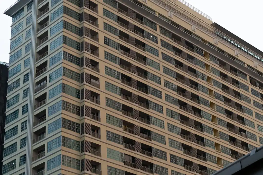 A tall modern residential building with many balconies and windows