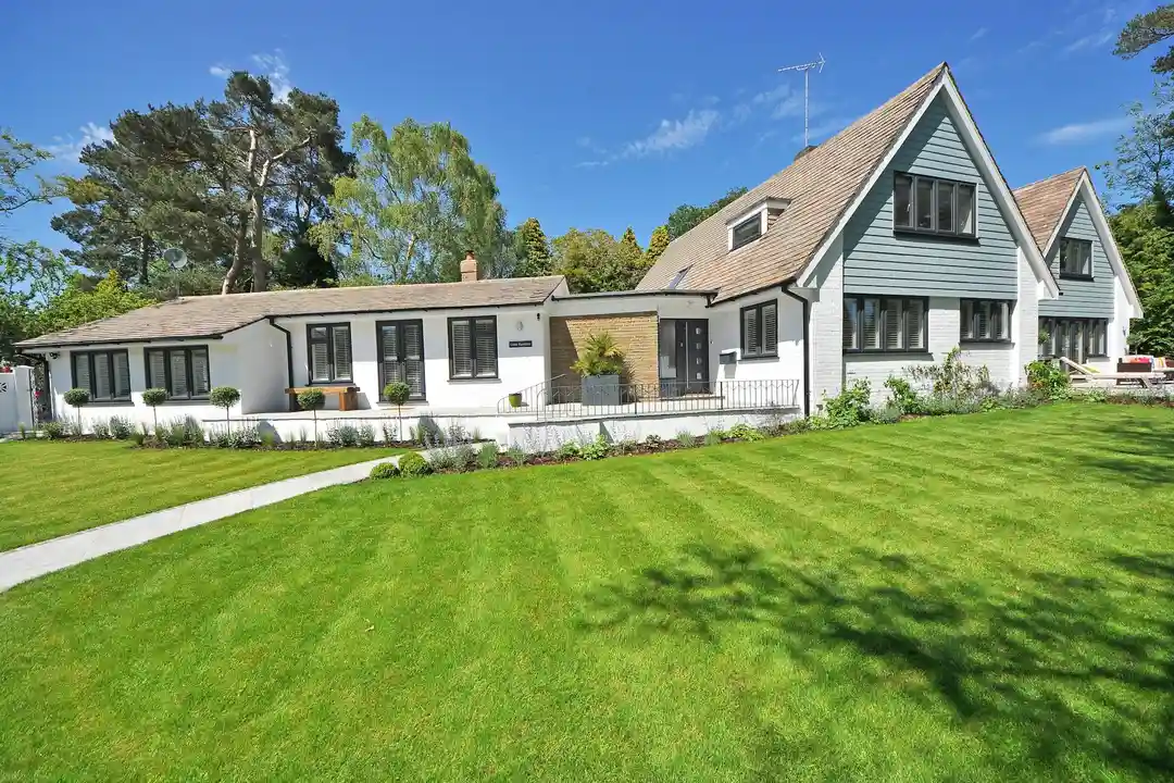 A well-kept suburban home with a wide, green lawn and a curved walkway