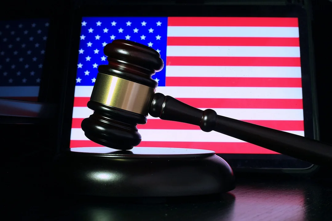 Gavel resting on a table in front of an American flag, suggesting a formal HOA hearing.