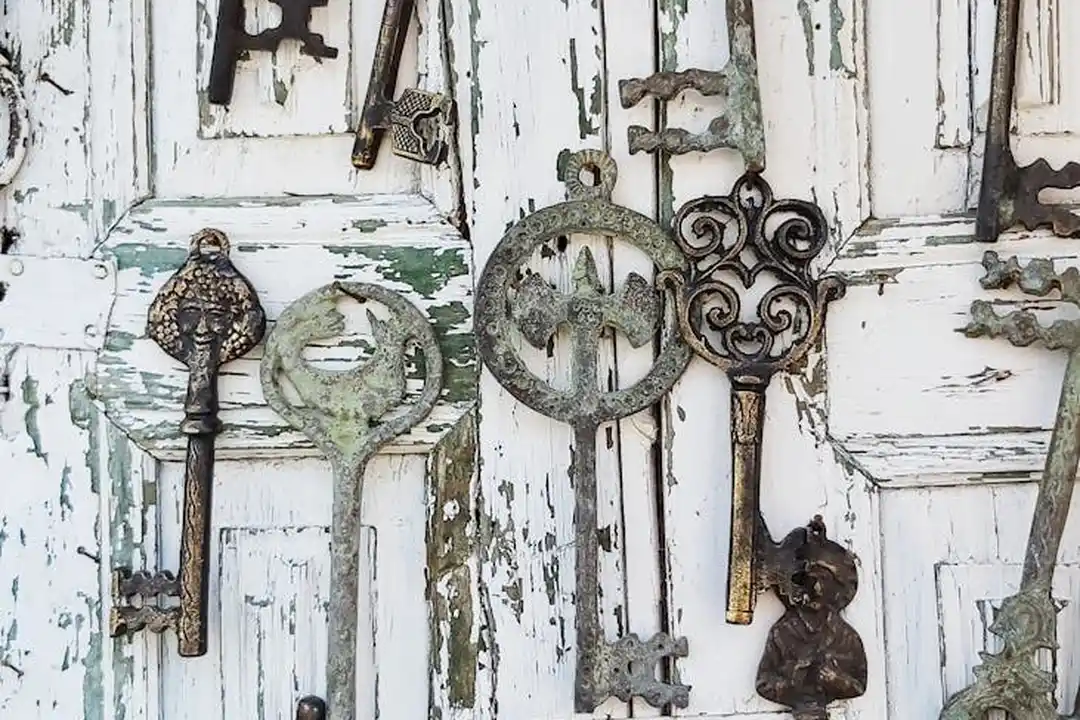An assortment of old, rusted keys hanging on a weathered white door, symbolizing HOA access and privacy concerns.