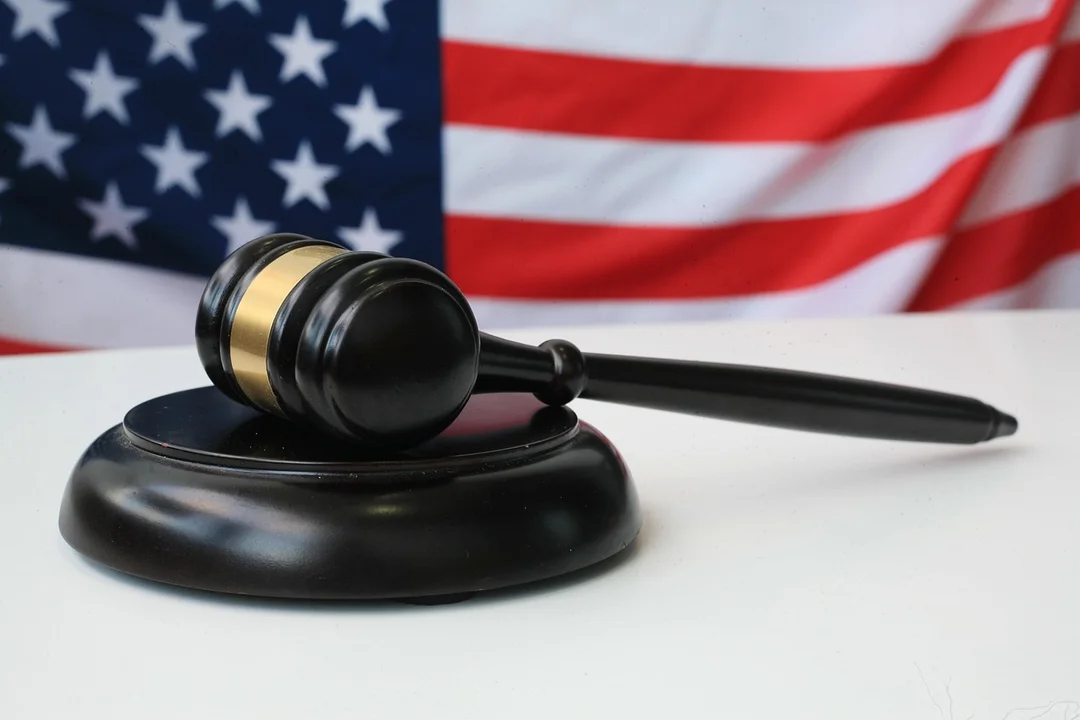 Gavel resting on a desk with an American flag in the background.