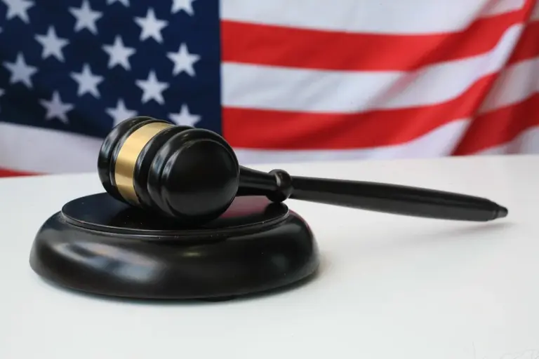 Gavel resting on a sound block with an American flag in the background