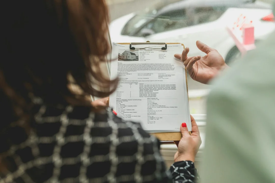 Two people review a clipboard with documents during an HOA meeting