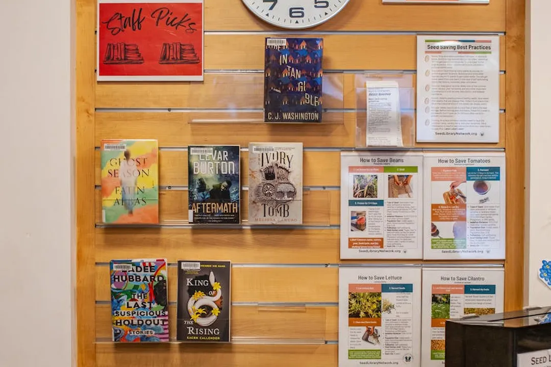 Display wall featuring books, pamphlets, and posters about HOA governance and meeting practices, with a clock at the top center.
