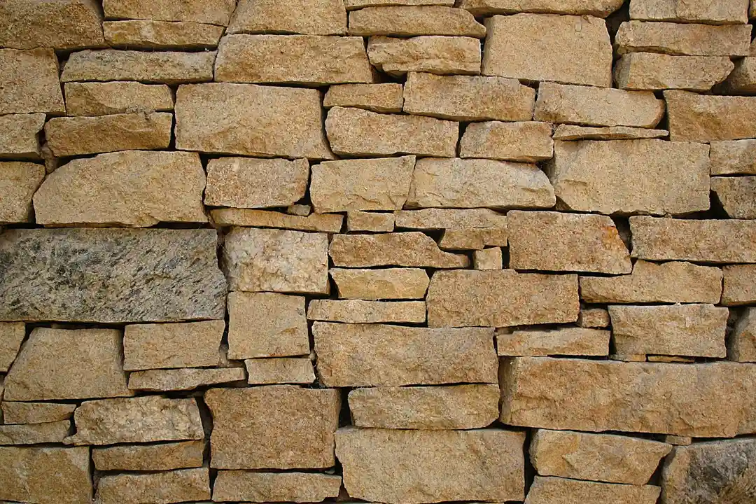 Close-up of a stacked stone wall used in masonry, illustrating durable foundation construction.