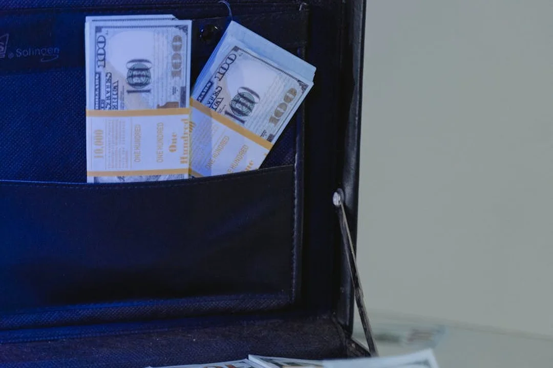 Close-up of a wallet with stacks of hundred-dollar bills
