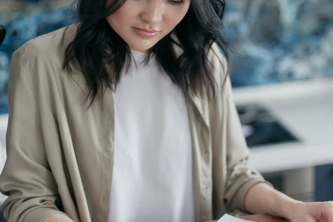 Person reviewing financial documents to illustrate long-term cost control strategies for HOA fees