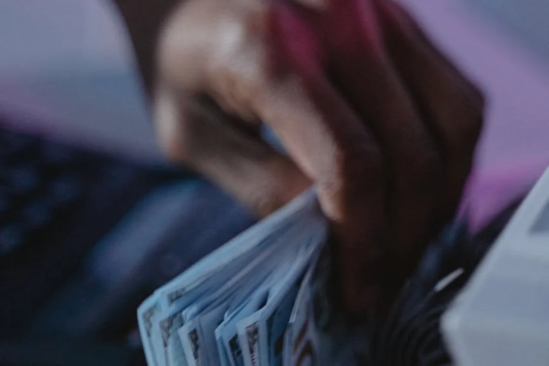 Close-up of a hand counting or holding a stack of cash