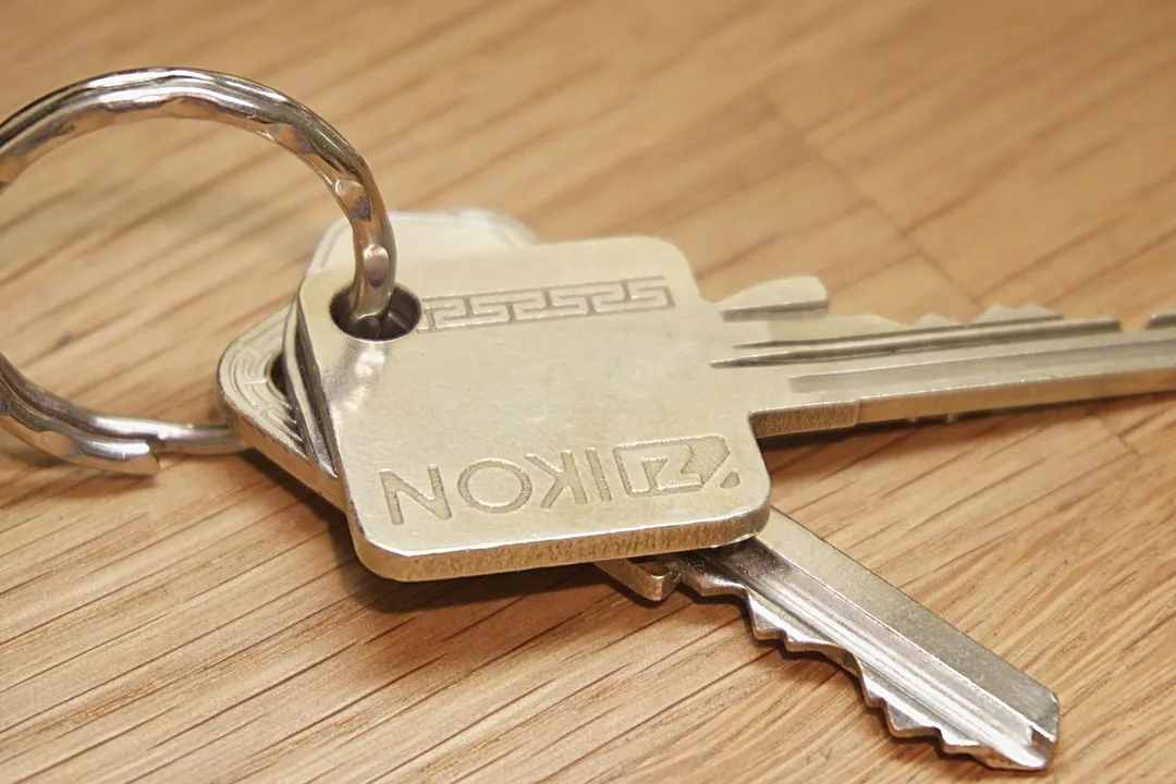 Close-up of house keys on a wooden surface, symbolizing homeownership and HOA considerations.