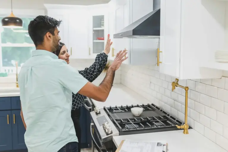 A couple in a modern kitchen discussing home features during a viewing.