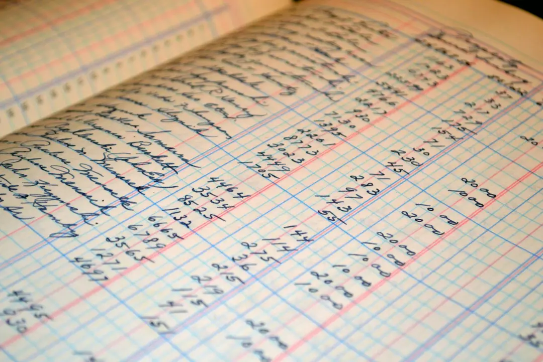 Close-up of a handwritten ledger with rows of numbers and columns, illustrating meticulous financial record-keeping.