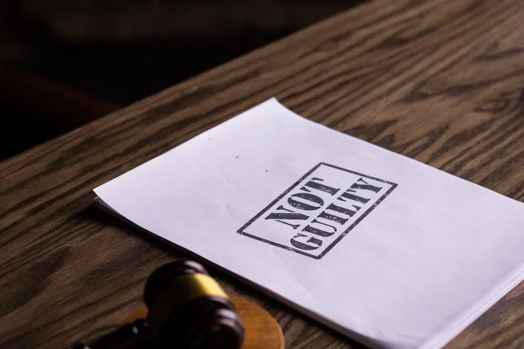 Envelope on a wooden surface with a bold 'NOT GUILTY' stamp