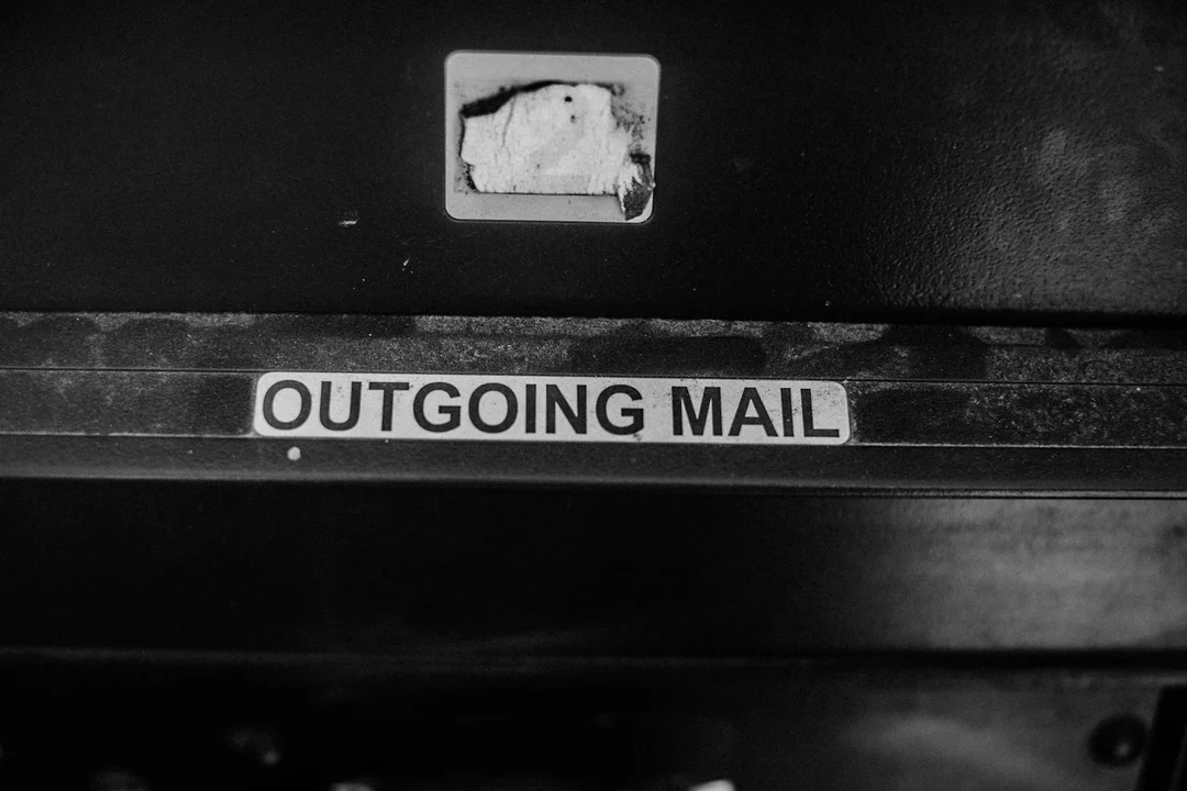 Black-and-white close-up of a mailbox with an 'OUTGOING MAIL' label