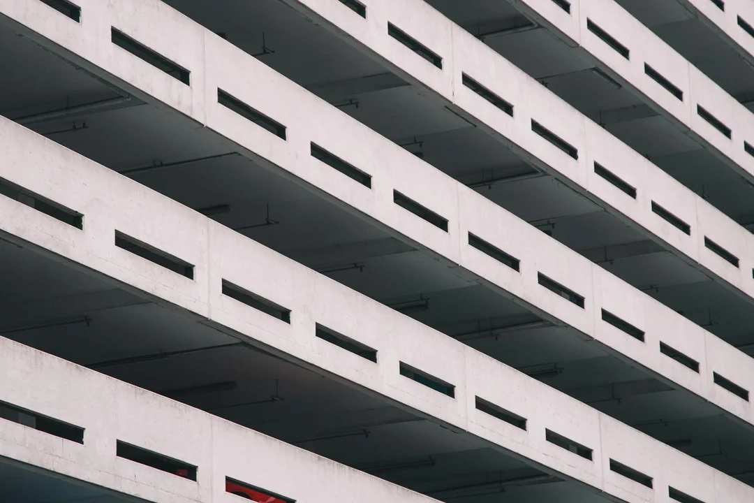 Exterior view of a multi-level concrete parking garage with repeating horizontal floors and openings.