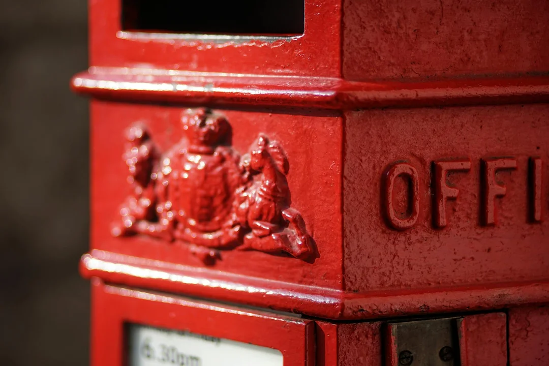 Close-up of a bright red mailbox with embossed details and a slot for letters.